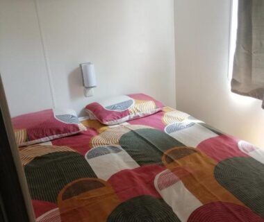 Chambre avec lit double et fenêtre dans le mobil home Chez 118 Alain