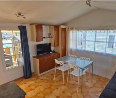 Séjour lumineux avec coin repas et télévision dans le mobil-home Chez Loulou et Bibou
