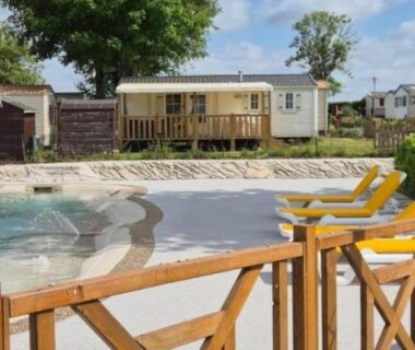 Piscine du camping avec transats et mobil-home en arrière-plan au Mobil-home Chez Loulou et Bibou