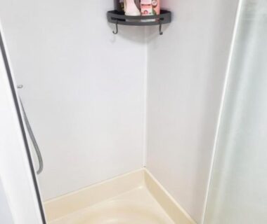 Cabine de douche avec étagère et flacons du mobil-home Chez Loulou et Bibou au camping Le Ptit Rio