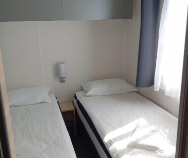 Chambre lumineuse avec deux lits simples dans le Mobil home Chrisali