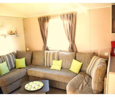 Salon avec banquette et table basse dans le mobil home MH-A004 du Camping LA CARABASSE