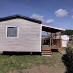 Mobil-home sur pelouse avec terrasse couverte au Camping LE LAC DES RÊVES MH-A020