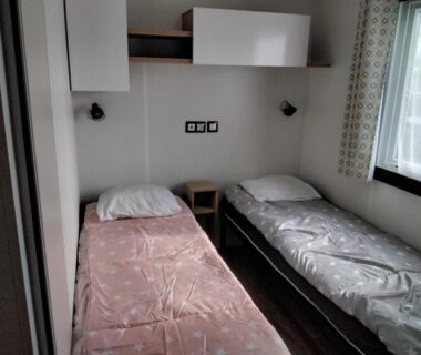 Intérieur avec deux lits simples dans le mobil-home MH-A020 au camping Le Lac des Rêves