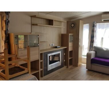Séjour avec canapé et cheminée dans le mobil-home MH-A026 du Camping LE LAC DES RÊVES