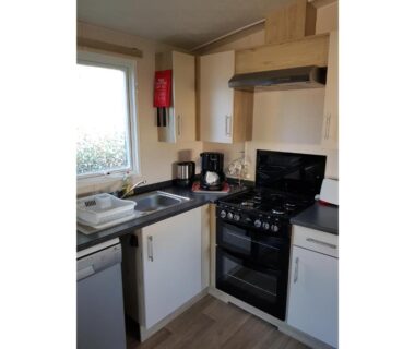Cuisine intérieure avec plaque, four et évier dans le mobil-home MH-A026 au Camping LE LAC DES RÊVES