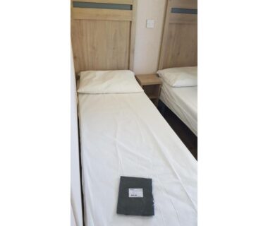 Intérieur de mobil-home lits simples avec serviette dans le Camping LE LAC DES RÊVES 4 étoiles MH-A026