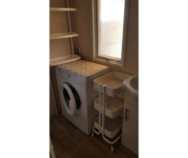 Coin buanderie avec lave-linge et évier dans le mobil-home MH-A026 du Camping LE LAC DES RÊVES