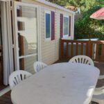 Terrasse avec table parasol et chaises du Mobil-home Confort camping le bois Masson