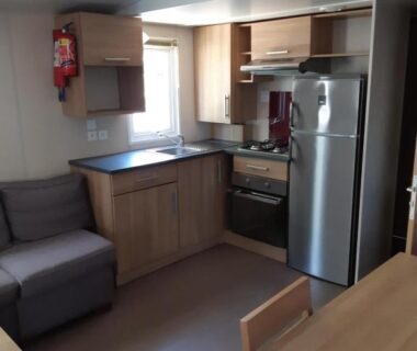 Intérieur kitchenette et coin salon dans le Mobil-home Confort camping le bois Masson