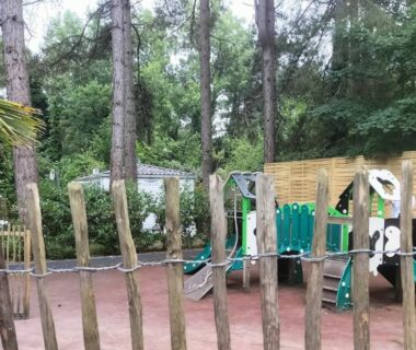 Aire de jeux en forêt entourée de pins au Mobil home Côte d'Opale