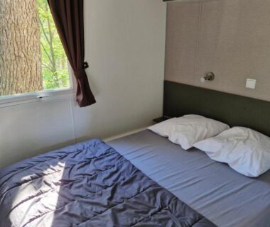 Chambre avec lit double et fenêtre dans le Mobil home Côte d'Opale