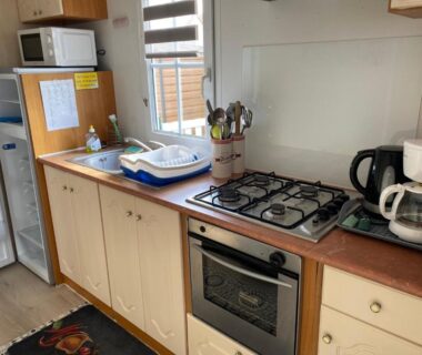 Coin cuisine équipé avec cuisinière et four dans le mobil home Cristal