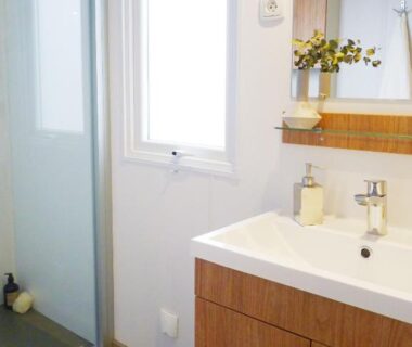 Salle de bain avec lavabo et douche dans le mobil-home Dan Dom