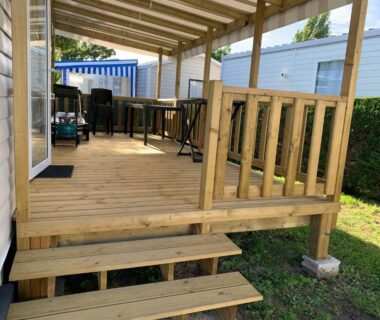 Terrasse couverte avec table et marches du mobil-home Dan Dom