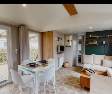 Salon intérieur avec terrasse vitrée et coin repas du Mobil home Domaine de Kerlann