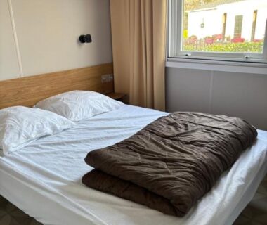 Chambre avec lit et fenêtre donnant sur l'extérieur du Mobil home Domaine de Kerlann