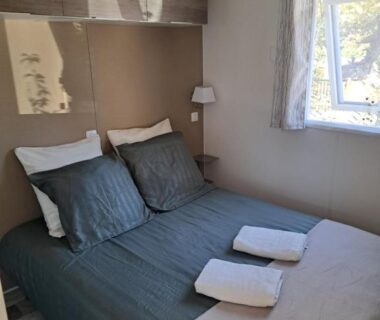 Chambre avec lit double et serviettes dans le mobil home Domaine de la Forge