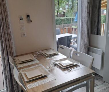 Coin repas intérieur avec table et chaises dans le Mobil home Domaine de la Forge