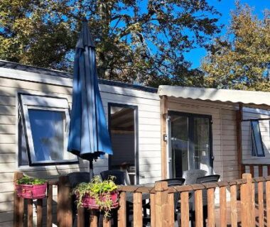 Terrasse en bois avec parasol et jardinières du mobil home Domaine de la Forge