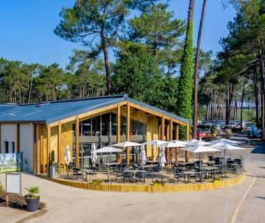 Terrasse extérieure avec parasols et tables dans le camping Mobil-home Dunes de Contis Chez Bibou
