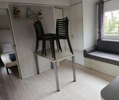 Intérieur avec table et chaises empilées dans le mobil-home Dunes de Contis Chez Bibou