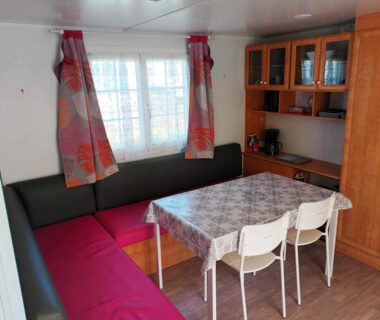 Coin repas avec banquette et table du mobil home LA BAULE 437