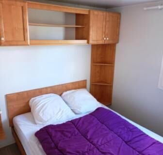 Chambre avec lit double et couette violette dans le Mobil home LA BAULE 437