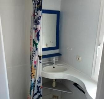 Salle de bain avec douche lavabo miroir et rideau coloré du mobil home LA BAULE 437