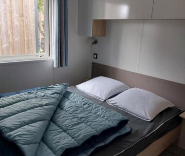 Chambre avec lit double et fenêtre dans le mobil-home La Perle Bleue Ouistreham