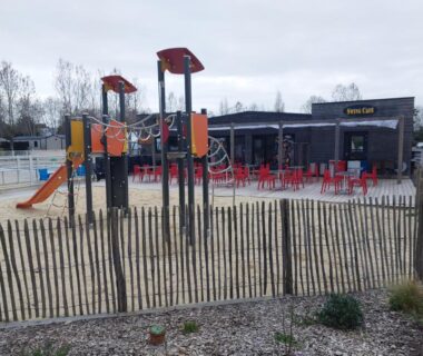 Aire de jeux avec toboggans et terrasse du camping La Perle Bleue