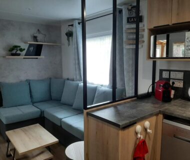 Intérieur avec canapé d'angle et kitchenette dans le mobil-home Le Bora Bora 202