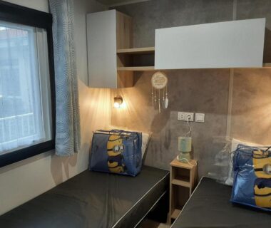 Chambre avec deux lits jumeaux et coussins Minions dans le mobil-home Le Bora Bora 202