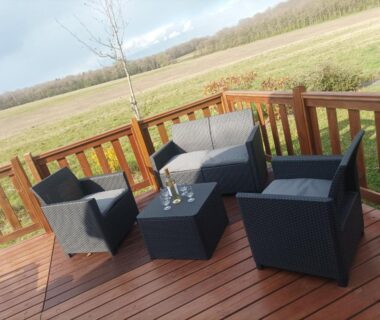 Terrasse en bois avec salon de jardin et vue sur la campagne du Mobil home Le Galland de Dugny