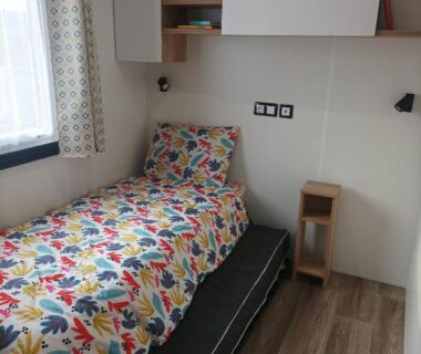 Chambre avec lit simple et rangements dans le mobil home Le Galland de Dugny