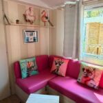 Coin salon avec canapé et coussins dans le mobil-home Le Manosely confort 6 pers Climatisé-Plages à proximité