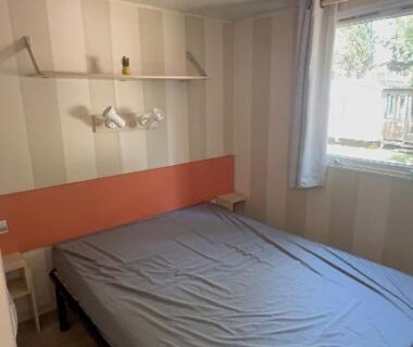 Chambre intérieure avec lit double et étagères dans le Mobil-home Le Manosely