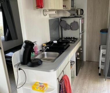 Cuisine équipée avec évier et plaques de cuisson dans le mobil home Le petit Paradis