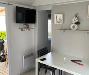 Coin repas avec table et télévision dans le mobil home Le petit Paradis 4-6 places camping les sables du midi
