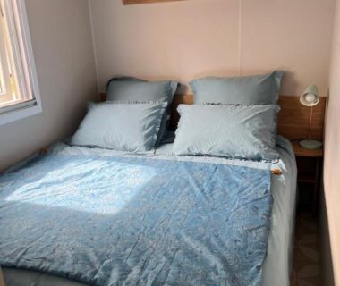 Chambre avec lit double fenêtre et étagères dans le Mobil-home Lège-Cap-Ferret