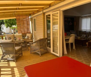 Terrasse couverte avec salon de jardin et baies vitrées du mobil-home Lège-Cap-Ferret