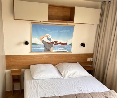 Chambre avec lit double et tableau au-dessus dans le mobil home Les Viviers