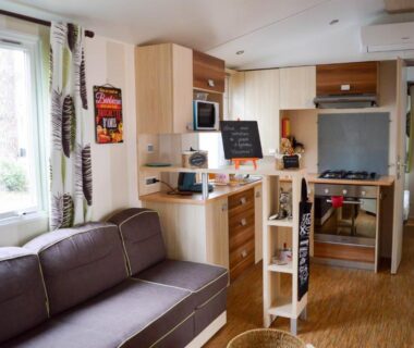 Séjour avec canapé et kitchenette dans le Mobil-home Mick et Stefie