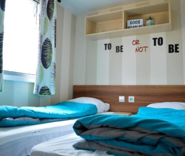 Dans la chambre deux lits simples et étagères du Mobil-home Mick et Stefie