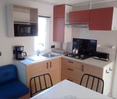 Cuisine avec micro-ondes cafetière et coin repas dans le Mobil home Neuf 6 places Climatisé