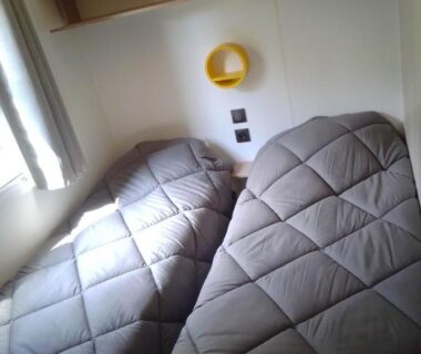 Chambre avec deux lits simples et fenêtre dans le Mobil home Neuf 6 places Climatisé