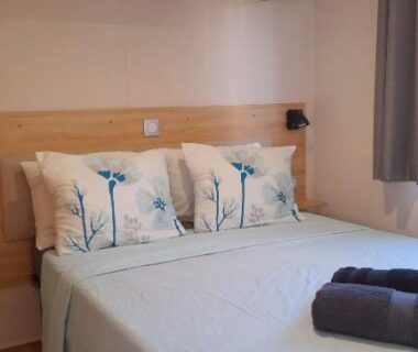 Chambre avec lit double et rangements en bois dans le mobil-home Ohana Mar Estang