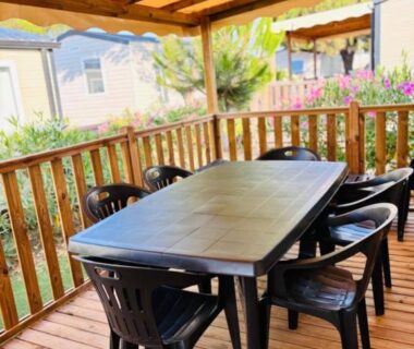 Terrasse couverte avec table et chaises en plastique du mobil-home Ohana Mar Estang