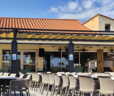 Terrasse extérieure avec rangées de tables et chaises au Mobil- home Ohana Mar Estang