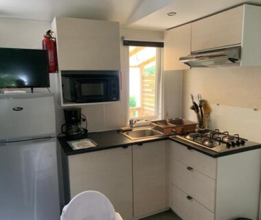 Coin cuisine équipé avec réfrigérateur et plaque dans le Mobil-home Ouistreham